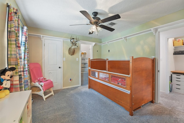 carpeted bedroom featuring visible vents, a textured ceiling, and ceiling fan