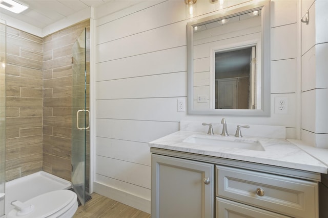 full bathroom featuring visible vents, toilet, wood finished floors, a shower stall, and vanity