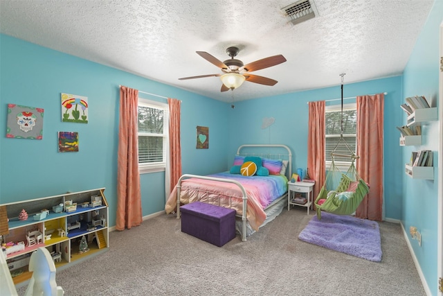 bedroom with baseboards, visible vents, ceiling fan, a textured ceiling, and carpet flooring