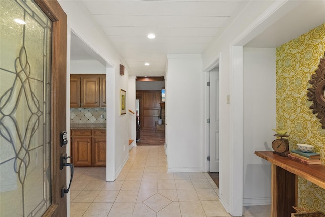 foyer featuring light tile patterned floors, recessed lighting, and baseboards