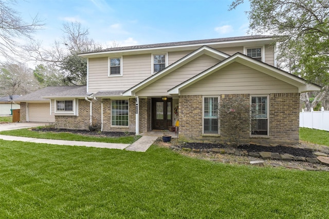 view of front of house with brick siding, a garage, a front lawn, and fence