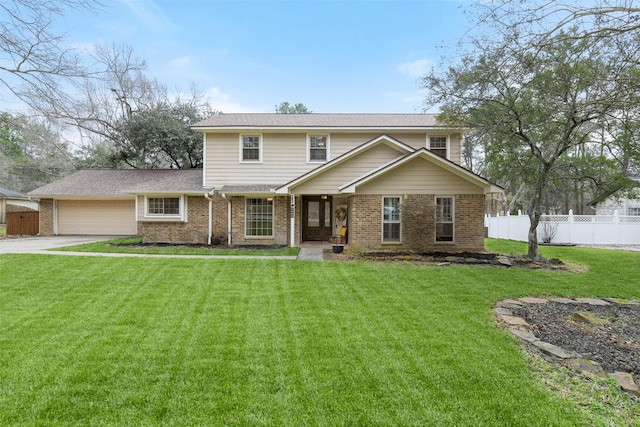 view of front of home featuring brick siding, a front yard, a garage, and fence