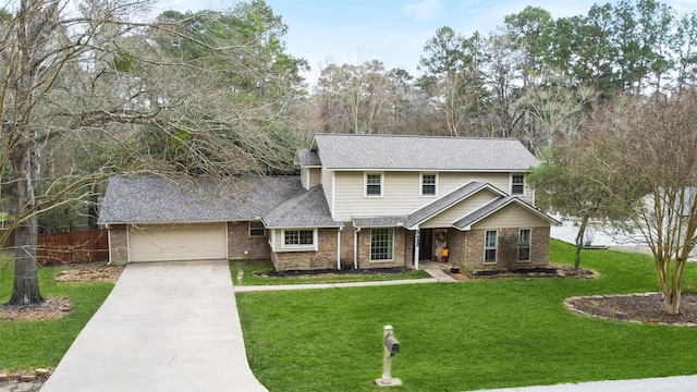 view of front of property with a front yard, fence, driveway, a garage, and brick siding