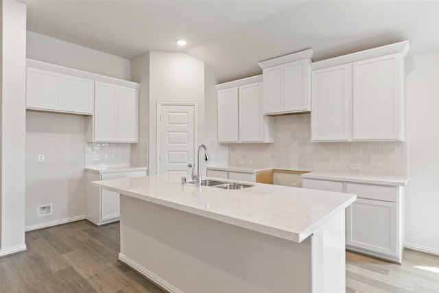 kitchen featuring a sink, light wood-style flooring, white cabinetry, a kitchen island with sink, and recessed lighting