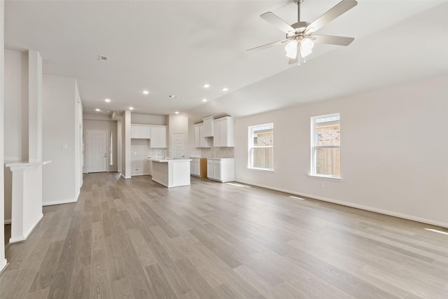unfurnished living room with light wood-style flooring, ceiling fan, baseboards, recessed lighting, and lofted ceiling