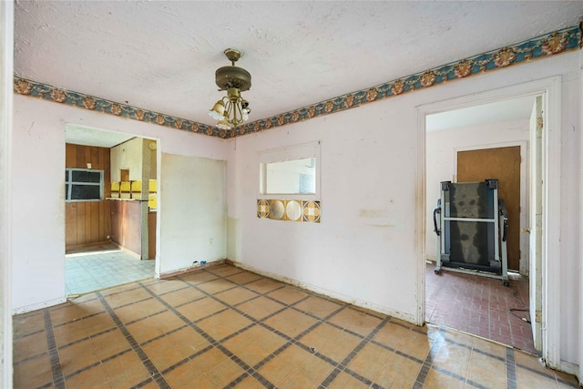 empty room with baseboards and a textured ceiling