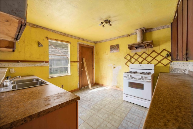 kitchen featuring light floors, baseboards, a sink, white gas range oven, and island range hood
