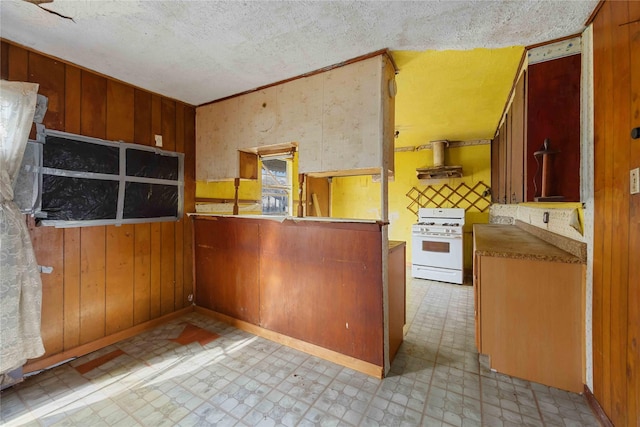 kitchen featuring ventilation hood, light floors, white gas stove, and wood walls