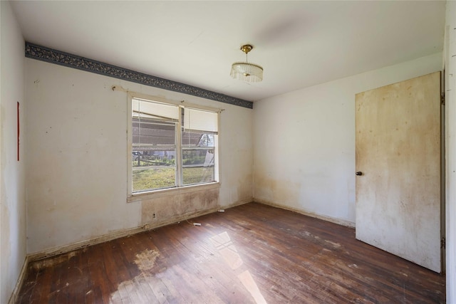 unfurnished room featuring baseboards and hardwood / wood-style flooring