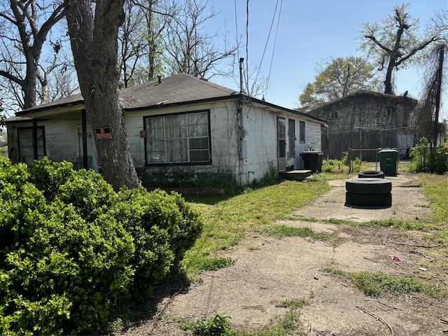 view of home's exterior featuring concrete block siding and fence
