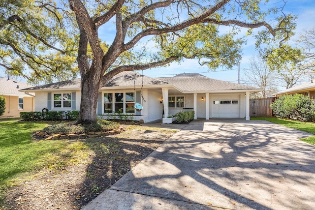 ranch-style house featuring fence, driveway, a front lawn, a garage, and brick siding