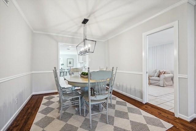 dining room with baseboards, wood finished floors, and ornamental molding