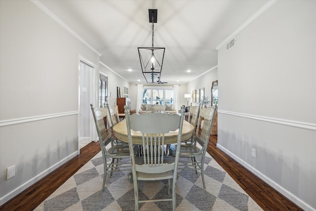 dining area featuring crown molding, wood finished floors, visible vents, and baseboards