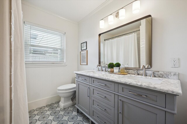 bathroom with toilet, ornamental molding, baseboards, and a sink