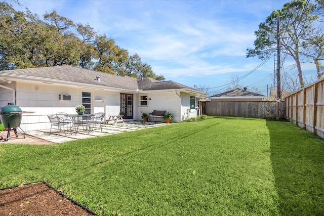 back of house with a shingled roof, a patio, a lawn, and a fenced backyard
