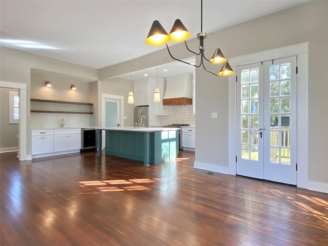 kitchen featuring custom range hood, open shelves, premium appliances, white cabinets, and light countertops