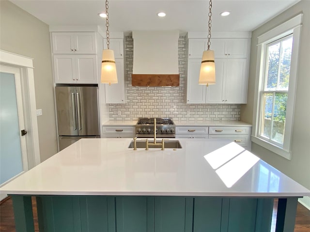 kitchen featuring custom exhaust hood, light countertops, tasteful backsplash, and high end refrigerator