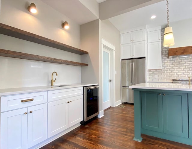 kitchen featuring beverage cooler, open shelves, a sink, light countertops, and high end refrigerator