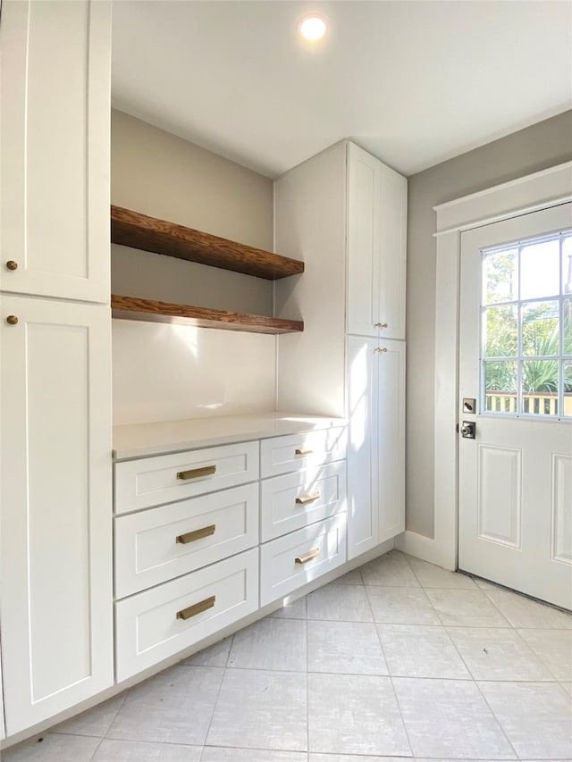 kitchen with white cabinetry, open shelves, light tile patterned floors, and light countertops