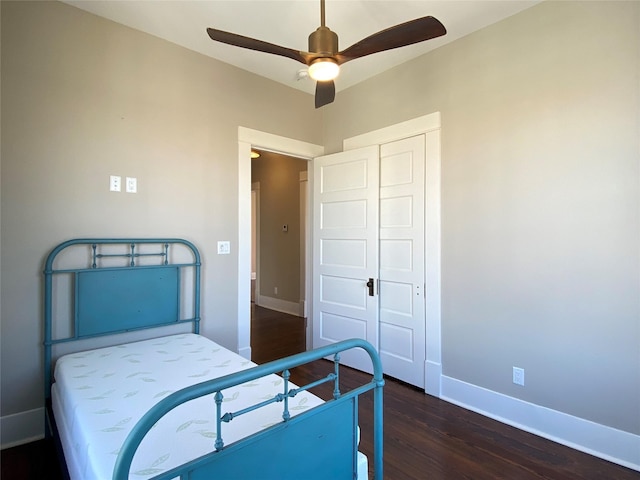 bedroom featuring a closet, a ceiling fan, baseboards, and wood finished floors