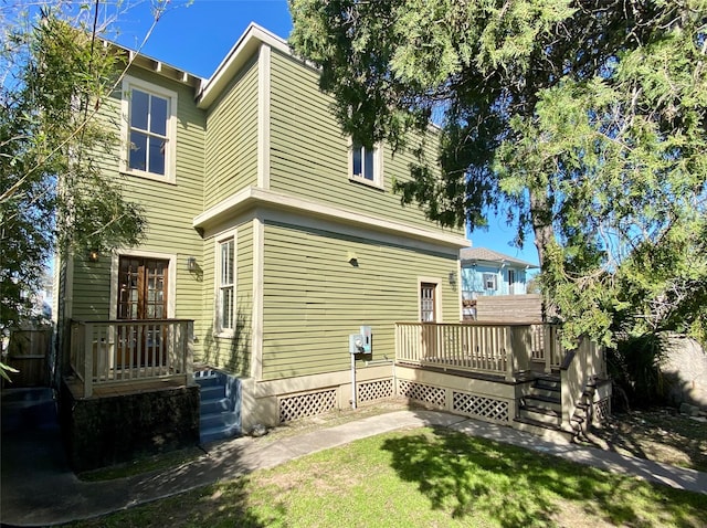 rear view of property with a wooden deck and fence