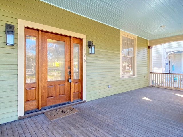 view of exterior entry featuring covered porch