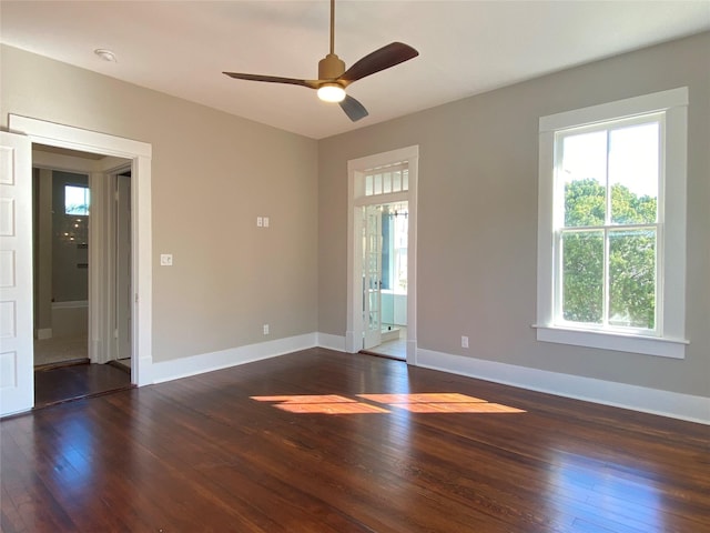 unfurnished room with ceiling fan, baseboards, and dark wood finished floors