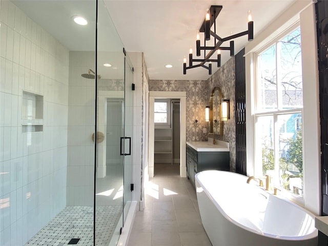 bathroom featuring tile walls, plenty of natural light, tile patterned floors, and a shower stall