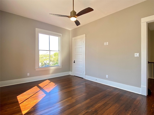 unfurnished room featuring dark wood-style floors, ceiling fan, and baseboards