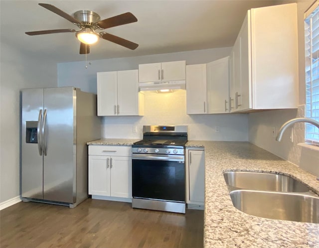 kitchen with under cabinet range hood, a sink, wood finished floors, white cabinetry, and appliances with stainless steel finishes