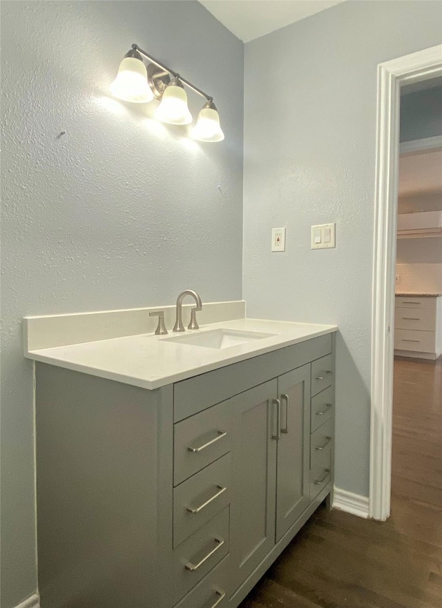 bathroom with vanity, baseboards, and wood finished floors