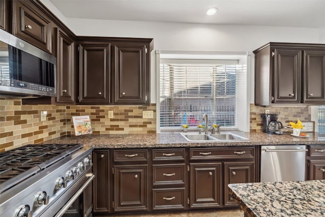 kitchen with tasteful backsplash, dark brown cabinets, stainless steel appliances, and a sink