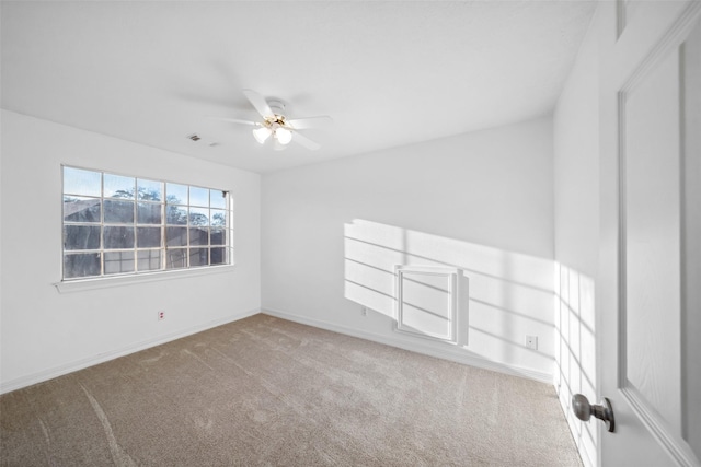 carpeted spare room featuring baseboards and ceiling fan