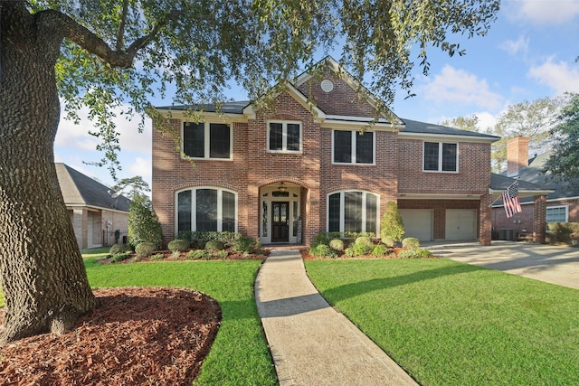 view of front facade with brick siding, driveway, an attached garage, and a front yard