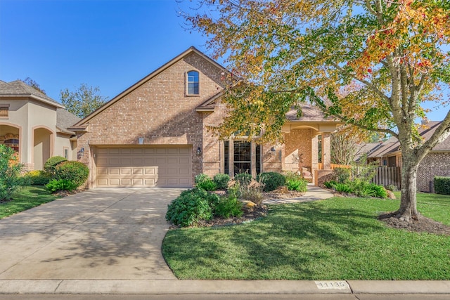 view of front of property with brick siding, a garage, driveway, and a front yard