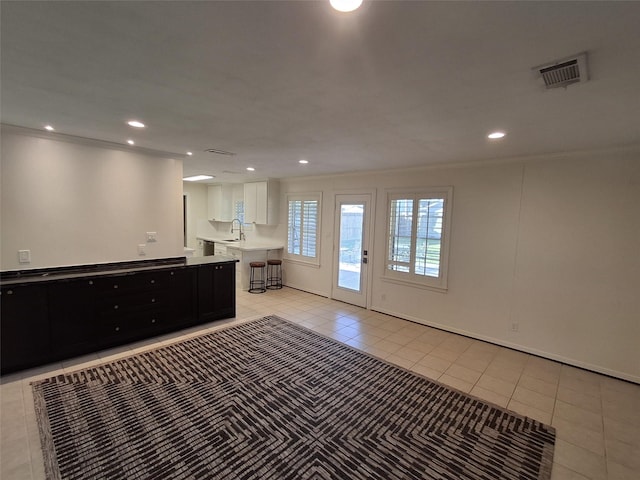 interior space with visible vents, ornamental molding, a sink, recessed lighting, and light tile patterned floors