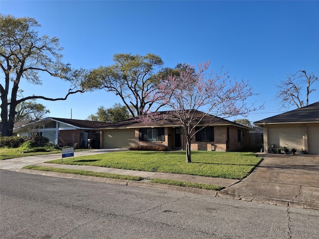 view of front facade with brick siding, a garage, a front lawn, and driveway