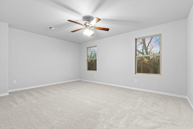 spare room with visible vents, baseboards, carpet, and a healthy amount of sunlight