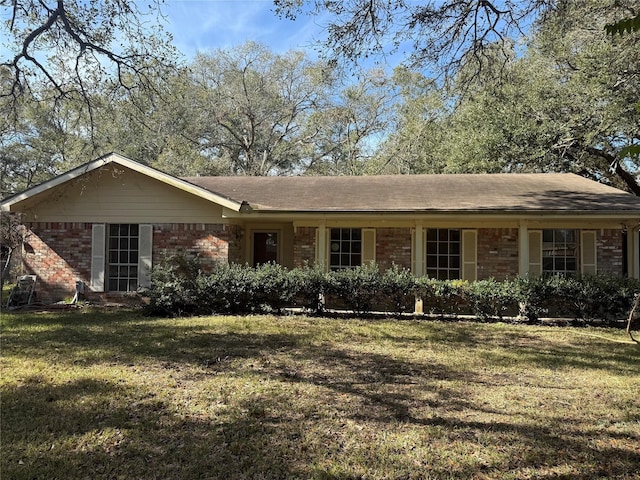 single story home featuring brick siding and a front lawn