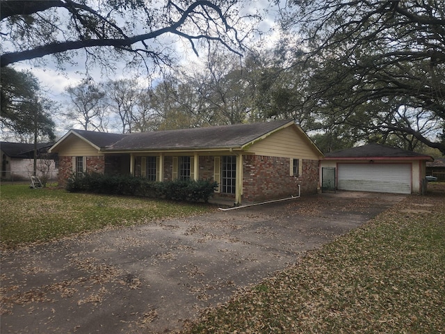 ranch-style home with a detached garage, brick siding, and an outdoor structure