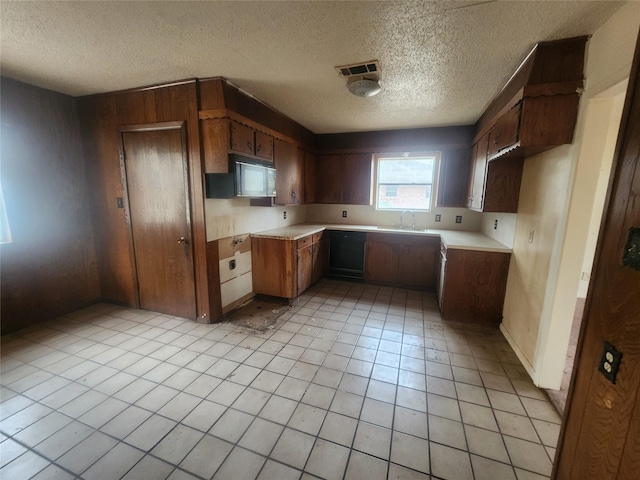 kitchen with light tile patterned floors, visible vents, light countertops, black microwave, and a textured ceiling