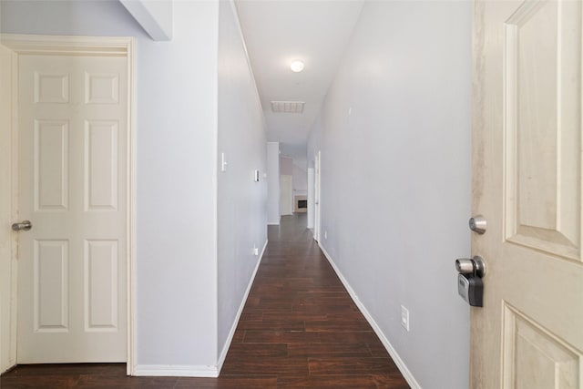 corridor with dark wood finished floors, baseboards, and visible vents