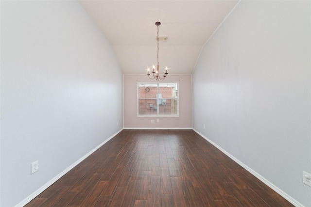 spare room with vaulted ceiling, a notable chandelier, dark wood-style floors, and baseboards