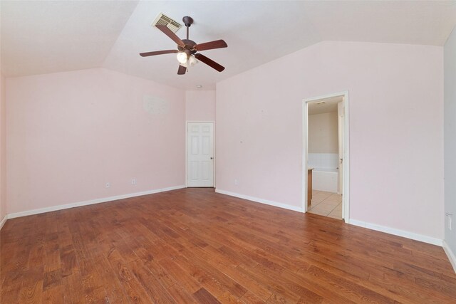 unfurnished room featuring baseboards, lofted ceiling, and wood finished floors