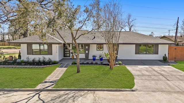 view of front of home featuring a front lawn, concrete driveway, and roof with shingles