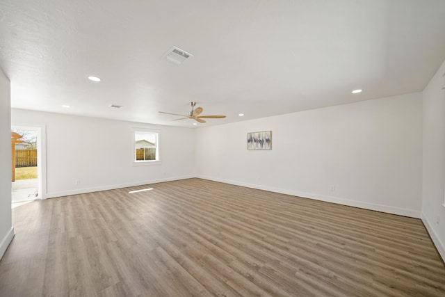 spare room featuring recessed lighting, wood finished floors, visible vents, and baseboards