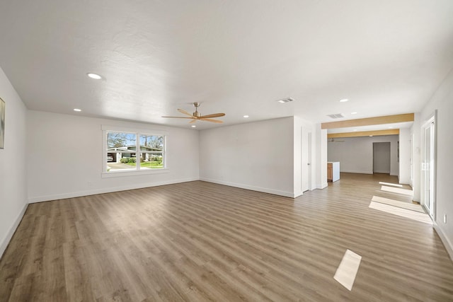 unfurnished living room with baseboards, visible vents, and light wood-type flooring