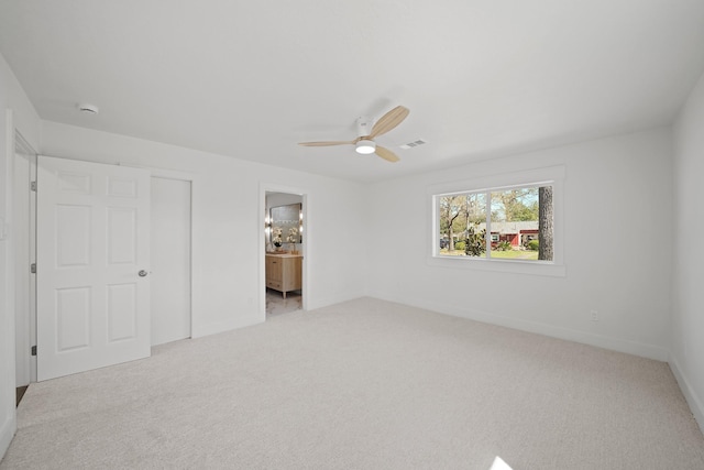 unfurnished bedroom with visible vents, a ceiling fan, ensuite bath, carpet flooring, and baseboards