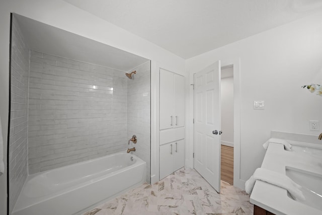 bathroom with marble finish floor, baseboards,  shower combination, and double vanity