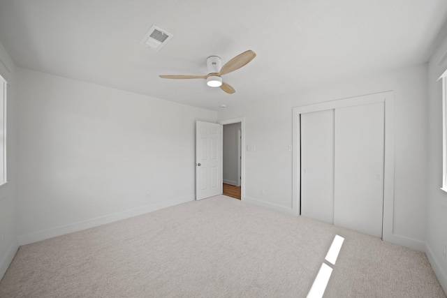 unfurnished bedroom featuring visible vents, a ceiling fan, a closet, carpet floors, and baseboards